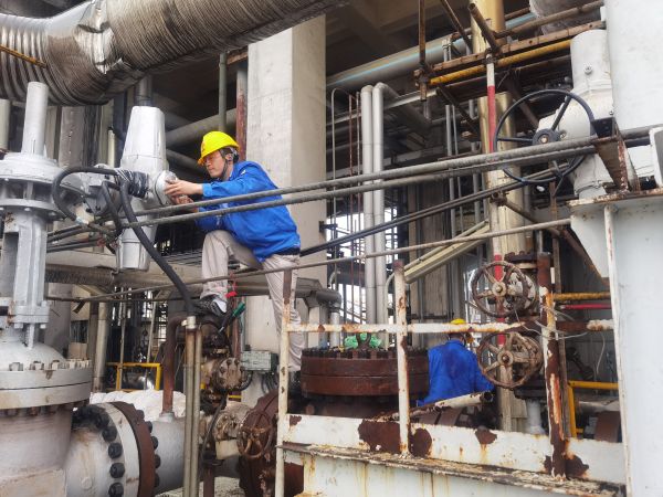 氣化爐上，柳曦、徐騰飛冒雨調(diào)試氣化爐電動(dòng)閥.jpg
