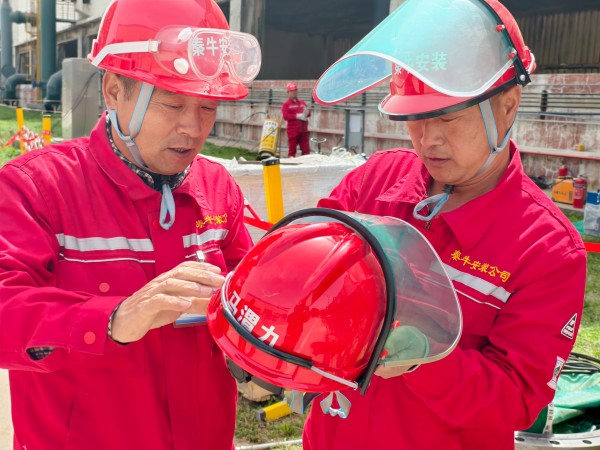 141744595056281756.jpg 團結(jié)協(xié)作 施工人員正在為其工友安裝安全面罩.jpg