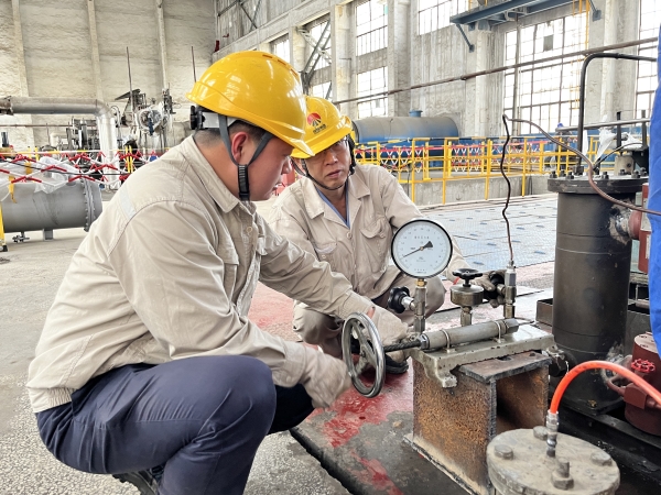 161744795121176525.jpg 圖為師傅吳培榮指導徒弟陳東操作校驗儀.JPG